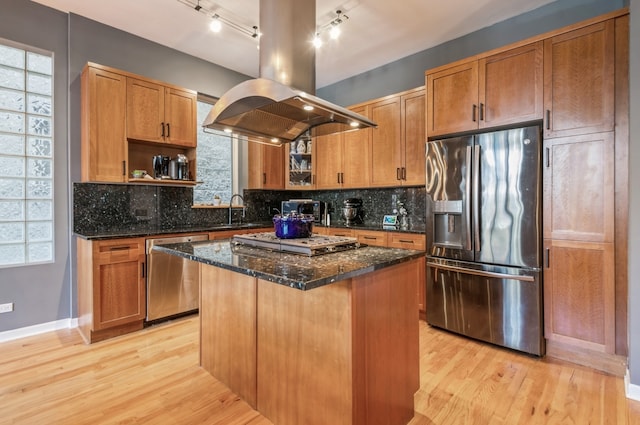 kitchen with a center island, decorative backsplash, stainless steel appliances, and island range hood