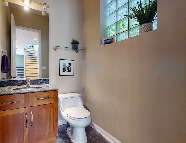 bathroom featuring toilet, vanity, and tile patterned flooring