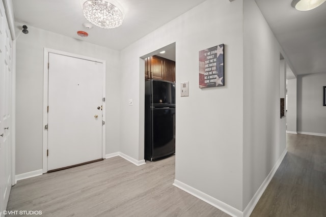 foyer entrance with a chandelier and light wood-type flooring