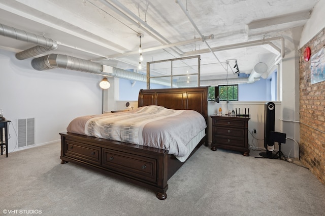 bedroom with light carpet and brick wall