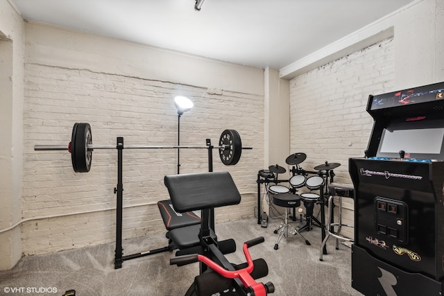 workout area featuring brick wall and light colored carpet