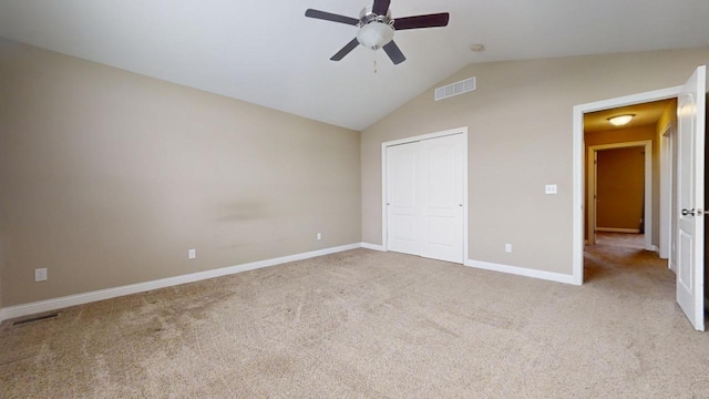 unfurnished bedroom with ceiling fan, lofted ceiling, light colored carpet, and a closet