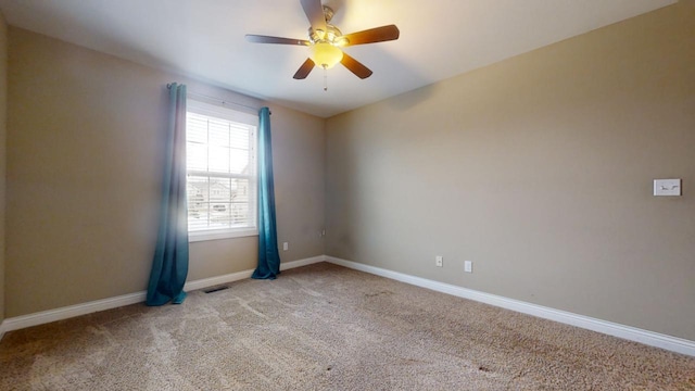 carpeted spare room featuring ceiling fan