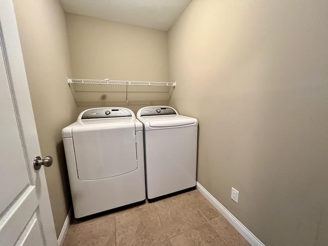 laundry room with light tile patterned floors and washer and clothes dryer