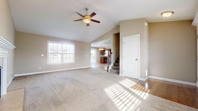 unfurnished living room featuring vaulted ceiling, light colored carpet, and ceiling fan