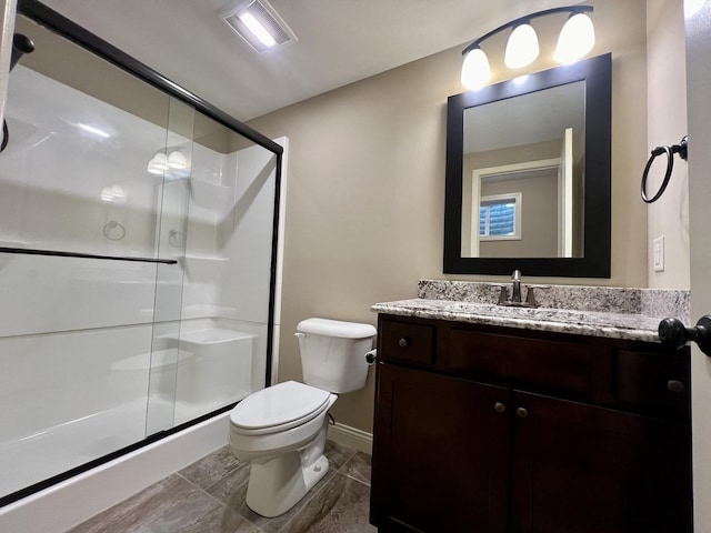 bathroom featuring vanity, toilet, and a shower with door