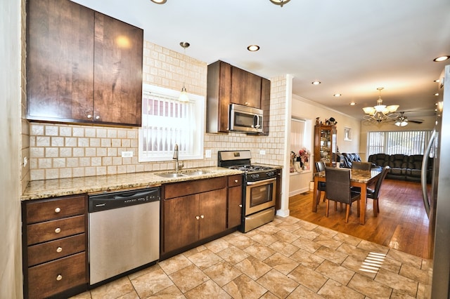 kitchen featuring stainless steel appliances, sink, plenty of natural light, and decorative light fixtures