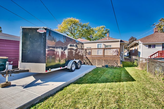 back of house featuring a wooden deck and a lawn