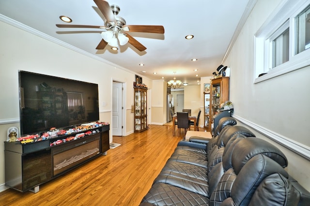 living room featuring ornamental molding, hardwood / wood-style flooring, and ceiling fan with notable chandelier