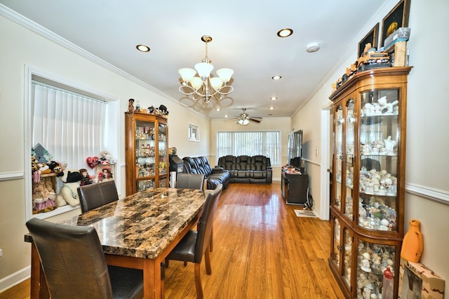 dining space featuring crown molding, hardwood / wood-style floors, and ceiling fan with notable chandelier