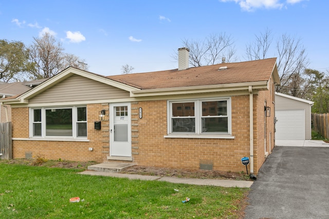 view of front of property featuring an outbuilding, a garage, and a front yard