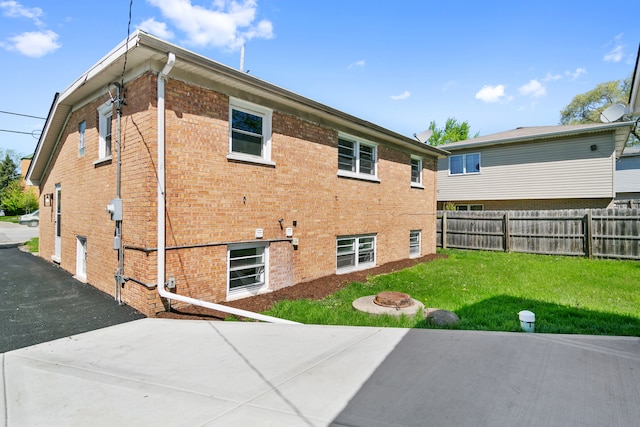 rear view of property featuring a lawn and a patio area