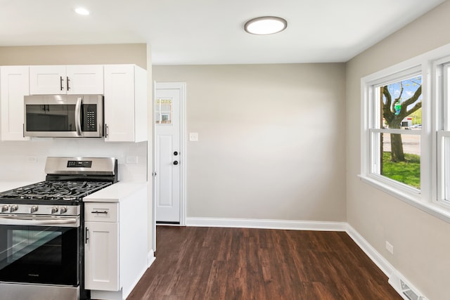 kitchen with white cabinets, dark hardwood / wood-style flooring, and appliances with stainless steel finishes