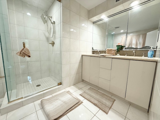 bathroom featuring tile walls, vanity, tile patterned flooring, and walk in shower