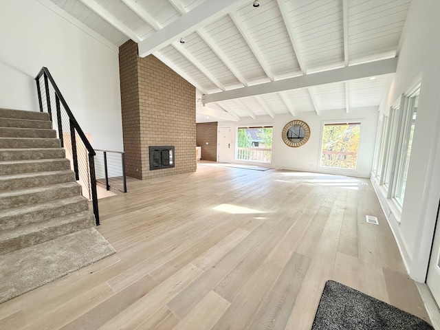 unfurnished living room featuring beamed ceiling, wood-type flooring, high vaulted ceiling, and wooden ceiling