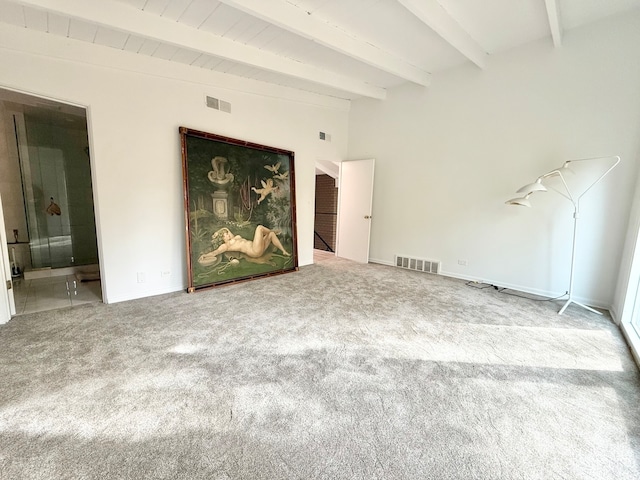 unfurnished living room featuring beamed ceiling and carpet flooring