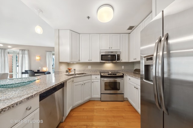 kitchen featuring stainless steel appliances, light wood-type flooring, and white cabinets