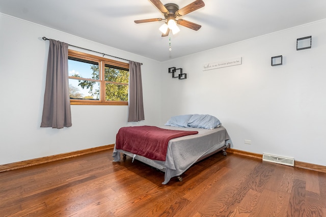 bedroom featuring ornamental molding, hardwood / wood-style floors, and ceiling fan