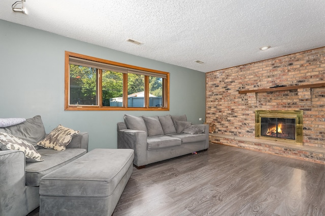 living room featuring hardwood / wood-style floors, a fireplace, and a textured ceiling