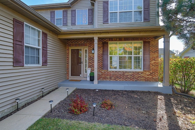 view of exterior entry featuring covered porch