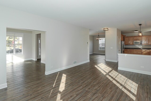 unfurnished living room featuring ceiling fan and dark hardwood / wood-style flooring