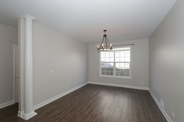 unfurnished dining area with an inviting chandelier, dark wood-type flooring, and decorative columns