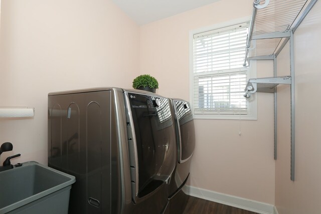 clothes washing area featuring dark wood-type flooring, sink, and separate washer and dryer