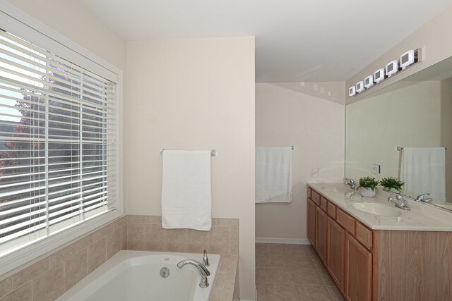 bathroom featuring vanity, tile patterned floors, tiled tub, and a wealth of natural light