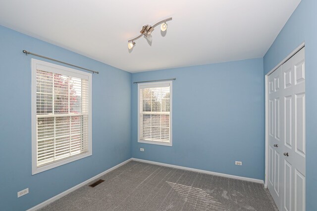 unfurnished room featuring carpet and plenty of natural light