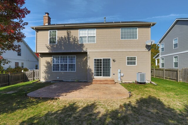 back of house with cooling unit, a patio, and a lawn