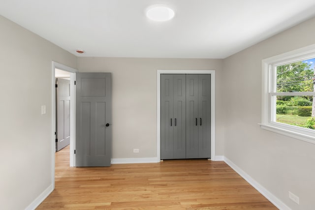 unfurnished bedroom with a closet and light hardwood / wood-style flooring