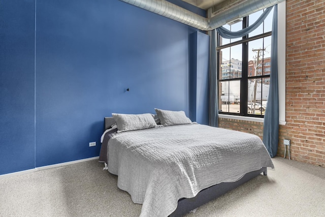 carpeted bedroom with brick wall