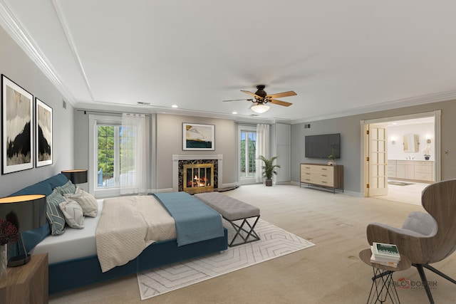 bedroom with connected bathroom, crown molding, light colored carpet, and a premium fireplace