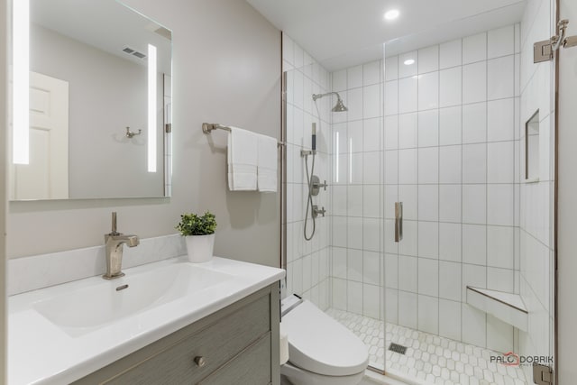 bathroom featuring vanity, toilet, and an enclosed shower