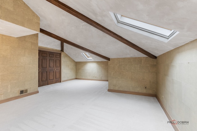 additional living space with lofted ceiling with skylight and carpet