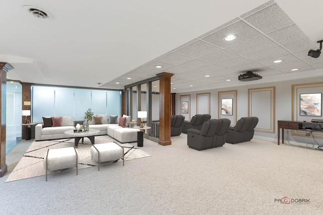 carpeted living room featuring a paneled ceiling and decorative columns