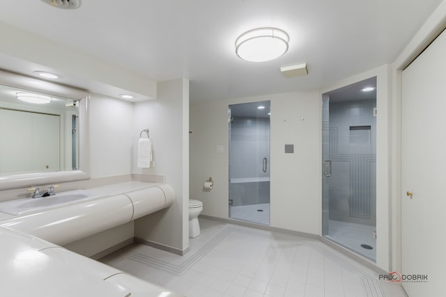 bathroom featuring toilet, vanity, tile patterned floors, and a shower with shower door