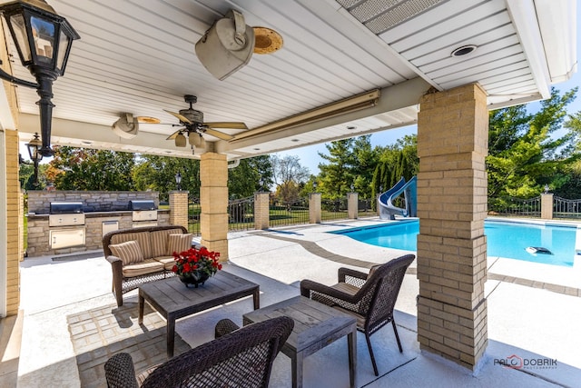 view of patio / terrace featuring ceiling fan, an outdoor kitchen, a grill, and a fenced in pool