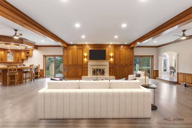 living room featuring hardwood / wood-style flooring, ornamental molding, and beamed ceiling