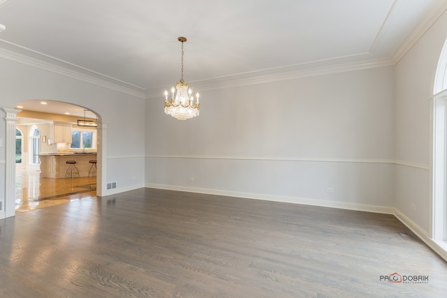 spare room with ornamental molding, dark hardwood / wood-style flooring, and a chandelier