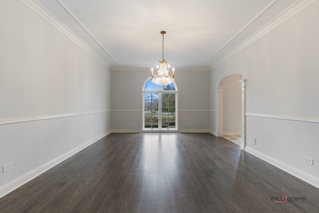 spare room with crown molding, dark wood-type flooring, and a chandelier