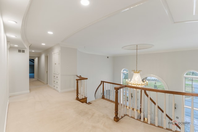 hall featuring crown molding, light colored carpet, and a notable chandelier