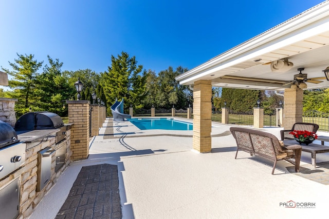 view of pool with a patio, a water slide, area for grilling, and ceiling fan