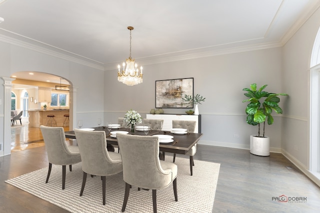 dining room featuring dark hardwood / wood-style flooring, crown molding, and an inviting chandelier