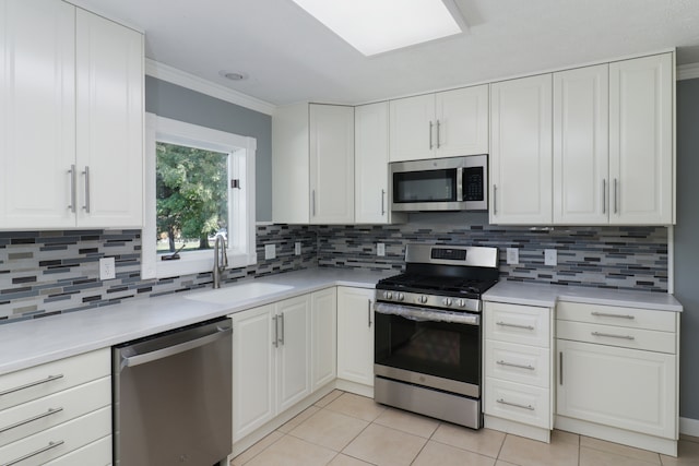 kitchen with decorative backsplash, white cabinets, appliances with stainless steel finishes, crown molding, and sink