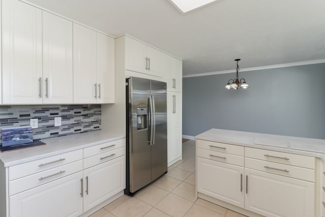 kitchen featuring crown molding, stainless steel fridge with ice dispenser, white cabinets, and tasteful backsplash