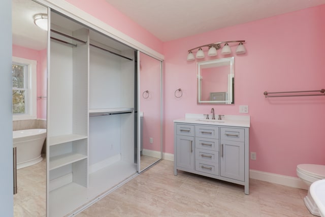 bathroom with vanity, toilet, and a bath