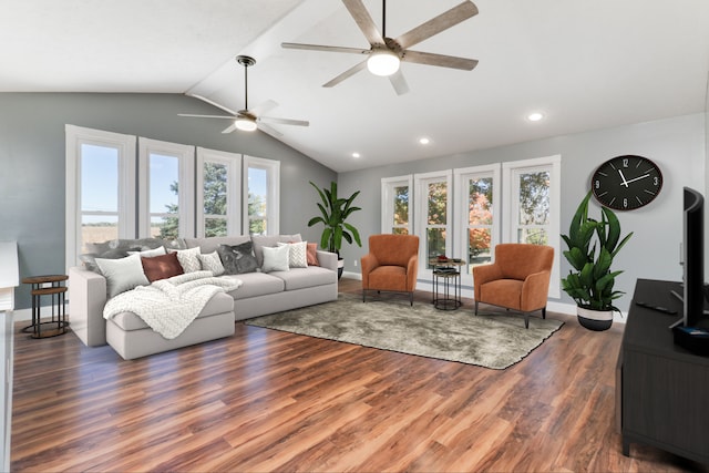 living room featuring dark wood-type flooring, ceiling fan, vaulted ceiling, and plenty of natural light