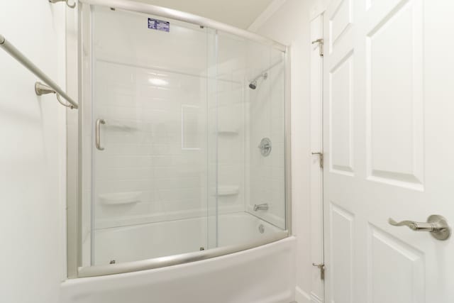 bathroom featuring combined bath / shower with glass door