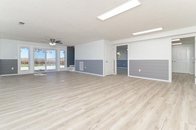 15054 E 2500 N Rd, Hudson, IL 61748 - unfurnished living room with light wood-type flooring, wainscoting, and a ceiling fan